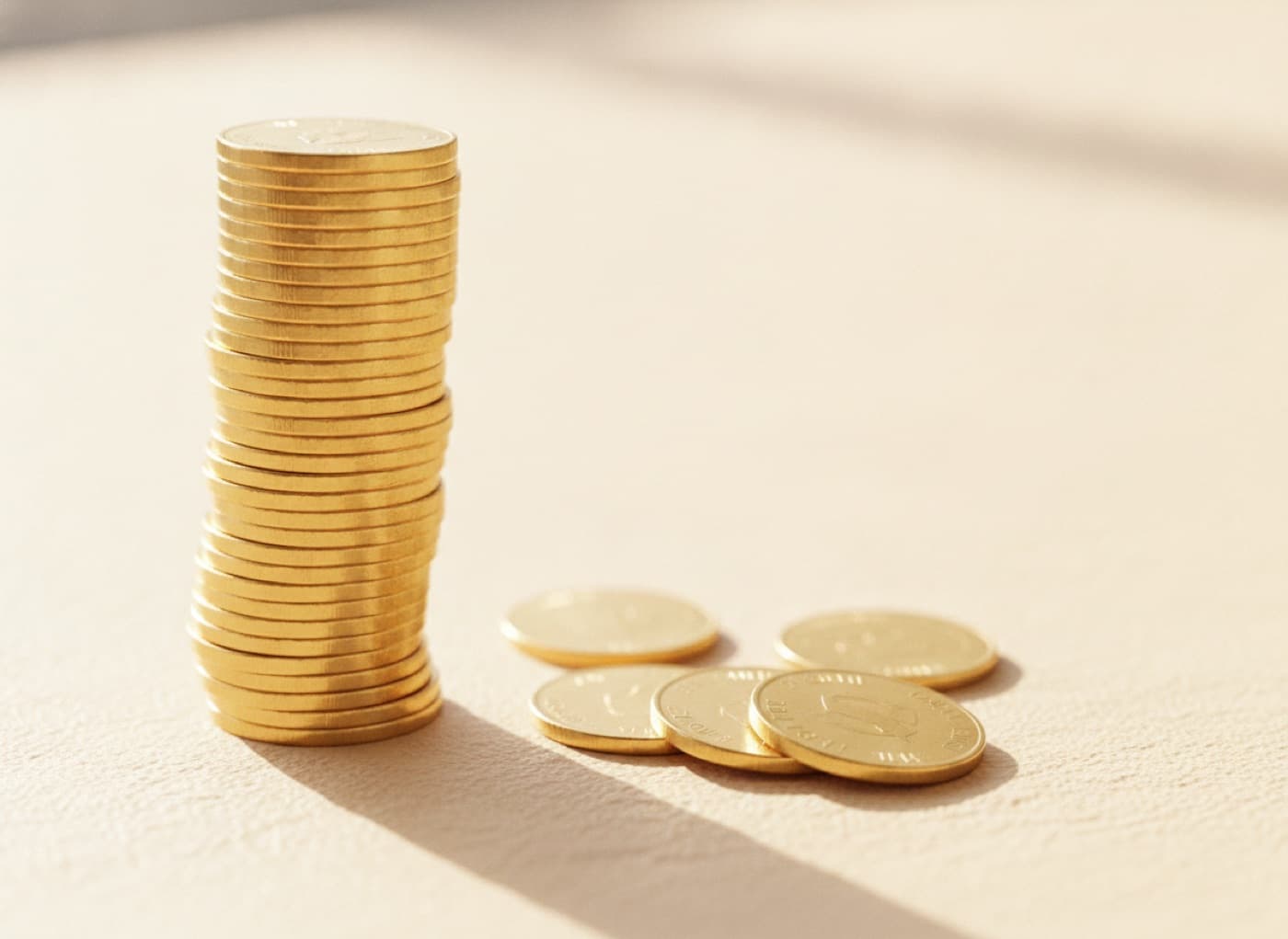 Anlage-Goldmünzen wie Krügerrand liegen gestapelt auf einem Tisch